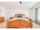 Cozy primary bedroom featuring a wood-carved bed frame, plush carpet, and large windows at 16622 S 32Nd Pl, Phoenix, AZ 85048