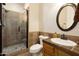 Well-kept bathroom showcasing tiled walk-in shower, toilet, vanity, and framed oval mirror at 17665 N 93Rd Way, Scottsdale, AZ 85255