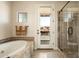 Bathroom featuring a soaking tub, walk-in shower, access to a private balcony, and decorative tile accents at 17665 N 93Rd Way, Scottsdale, AZ 85255