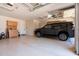 Spacious and clean garage featuring epoxy floors, storage cabinets, and an installed ceiling-mounted garage door opener at 17665 N 93Rd Way, Scottsdale, AZ 85255