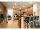 Well-lit kitchen with stainless steel appliances, wood cabinets, granite counters, and a breakfast bar with seating at 17665 N 93Rd Way, Scottsdale, AZ 85255