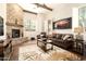 Stylish living room featuring a stone fireplace, wood beams, and comfortable leather sofa at 17665 N 93Rd Way, Scottsdale, AZ 85255