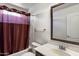 Simple bathroom featuring a tub with shower and a vanity with a framed mirror at 18222 W Lundberg St, Surprise, AZ 85388