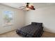 Comfortable bedroom with natural light, ceiling fan, and patterned bedding at 18222 W Lundberg St, Surprise, AZ 85388