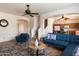 Cozy living room showcasing comfortable blue seating and stylish decor with staircase and kitchen views at 18222 W Lundberg St, Surprise, AZ 85388