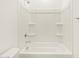 Clean bathroom featuring a white tub and shower combination with built-in shelves at 19390 N Fiano Dr, Maricopa, AZ 85138