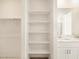 Bright bathroom features a white open shelf linen closet next to a double sink vanity at 19390 N Fiano Dr, Maricopa, AZ 85138