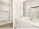 Modern bathroom featuring a double vanity, white cabinetry, and an open walk-in closet at 19390 N Fiano Dr, Maricopa, AZ 85138