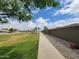 A green space includes a sidewalk next to a decorative block wall, with a community park in the background at 19390 N Fiano Dr, Maricopa, AZ 85138