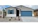 Charming single-story home with blue garage door, blue shutters and low maintenance landscaping at 19390 N Fiano Dr, Maricopa, AZ 85138