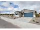 Single-story home featuring a blue garage door, blue shutters and drought tolerant rock landscaping at 19390 N Fiano Dr, Maricopa, AZ 85138