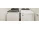 Bright laundry room features a new white Whirlpool washer and dryer set at 19390 N Fiano Dr, Maricopa, AZ 85138