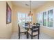 Charming breakfast nook with a glass table, seating for four, large windows, and stylish window coverings at 19607 N Flint Way, Surprise, AZ 85374