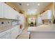 Well-lit kitchen with white cabinets, stainless steel appliances, tile backsplash, and adjacent breakfast nook with ample natural light at 19607 N Flint Way, Surprise, AZ 85374