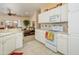 Bright kitchen with white cabinetry, tile backsplash, and stainless-steel appliances, open to the living room at 19607 N Flint Way, Surprise, AZ 85374