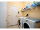 Functional laundry room with washer, dryer, shelving, and ample space for storage and sorting at 19607 N Flint Way, Surprise, AZ 85374