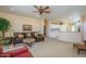 Spacious living room with a ceiling fan and an open layout, leading into the kitchen and dining area at 19607 N Flint Way, Surprise, AZ 85374