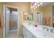 Bright main bathroom with double sinks, a large mirror, a walk-in shower, and ample storage at 19607 N Flint Way, Surprise, AZ 85374