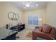 Well-lit office space with a ceiling fan, a comfortable couch, and a sleek glass-topped desk at 19607 N Flint Way, Surprise, AZ 85374