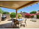 Inviting covered patio with an outdoor dining set and lush greenery, perfect for entertaining at 19607 N Flint Way, Surprise, AZ 85374