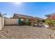 Large backyard featuring a covered patio, lounge chairs, rock landscaping and mature vegetation at 19930 N 98Th Ave, Peoria, AZ 85382