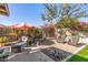 Charming backyard with a shaded patio, cozy seating area, and lush landscaping at 19930 N 98Th Ave, Peoria, AZ 85382