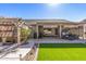 Inviting backyard featuring a covered patio, hot tub, lush greenery, and low-maintenance artificial turf at 19930 N 98Th Ave, Peoria, AZ 85382