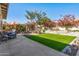 Spacious backyard featuring a well-manicured lawn, beautiful trees, and cozy seating area at 19930 N 98Th Ave, Peoria, AZ 85382