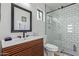 Bright bathroom featuring a modern vanity, sleek fixtures, and a walk-in shower with stylish white subway tile at 2033 E Janice Way, Phoenix, AZ 85022