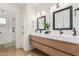 This elegant bathroom features a double sink vanity with modern fixtures and a separate shower area at 2033 E Janice Way, Phoenix, AZ 85022