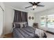 A cozy bedroom with a view of the pool area, accented by soft curtains and stylish wall decor at 2033 E Janice Way, Phoenix, AZ 85022