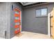 A modern front door painted bright red with glass inserts complemented by a dark gray textured wall and a welcome mat at 2033 E Janice Way, Phoenix, AZ 85022