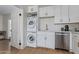 A functional kitchen with a stacked washer/dryer unit, stainless steel appliances, and clean white cabinetry at 2033 E Janice Way, Phoenix, AZ 85022