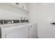 Efficient laundry room featuring modern washer and dryer units, with clean white shelving for storage at 2033 E Janice Way, Phoenix, AZ 85022