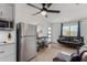 A brightly lit living room featuring a stainless steel refrigerator, dining table, and comfortable seating arrangement at 2033 E Janice Way, Phoenix, AZ 85022