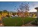 Stunning backyard with well-manicured lawn, modern lounge chairs, mature landscaping, and ambient lighting for evening relaxation at 20797 W Rattler Rd, Buckeye, AZ 85396