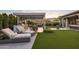 Beautiful backyard featuring a well-manicured lawn, lounge chairs, and an outdoor kitchen at 20797 W Rattler Rd, Buckeye, AZ 85396
