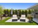 Inviting backyard featuring lounge chairs, built in grill area, and manicured landscaping at 20797 W Rattler Rd, Buckeye, AZ 85396