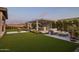 Inviting backyard space featuring a built-in outdoor kitchen, seating, firepit and synthetic grass at 20797 W Rattler Rd, Buckeye, AZ 85396