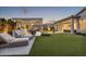 Beautifully designed backyard with a covered patio, built-in grill, comfortable lounge seating, and lush green lawn at 20797 W Rattler Rd, Buckeye, AZ 85396