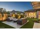 Inviting backyard featuring a cozy fire pit area with comfortable seating and a beautifully landscaped yard at 20797 W Rattler Rd, Buckeye, AZ 85396