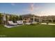 Serene backyard features an outdoor kitchen, sun loungers and lovely green artificial grass at 20797 W Rattler Rd, Buckeye, AZ 85396