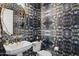 Eclectic powder room featuring a geometric mirror, pedestal sink, and vibrant wallpaper at 20797 W Rattler Rd, Buckeye, AZ 85396