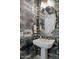 Stylish powder room with geometric mirror, white pedestal sink, and unique patterned wallpaper at 20797 W Rattler Rd, Buckeye, AZ 85396