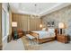 Bedroom with stylish decor, a wooden bed, textured accent wall, and ambient lighting at 20797 W Rattler Rd, Buckeye, AZ 85396