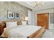 Comfortable bedroom featuring textured accent wall, a wooden bed, and decorative lighting at 20797 W Rattler Rd, Buckeye, AZ 85396