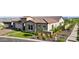Well-maintained home featuring a tile roof, stone accents, lush lawn, manicured shrubbery, and an attached garage at 20797 W Rattler Rd, Buckeye, AZ 85396