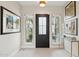 Bright entry featuring a black door with glass and decorative artwork on the walls at 20797 W Rattler Rd, Buckeye, AZ 85396