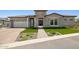Beautiful single-Gathering home featuring a well-manicured lawn, brick driveway, and stone accents at 20797 W Rattler Rd, Buckeye, AZ 85396