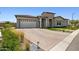 Charming single-story home with a brick driveway, two-car garage, and well-maintained landscaping at 20797 W Rattler Rd, Buckeye, AZ 85396